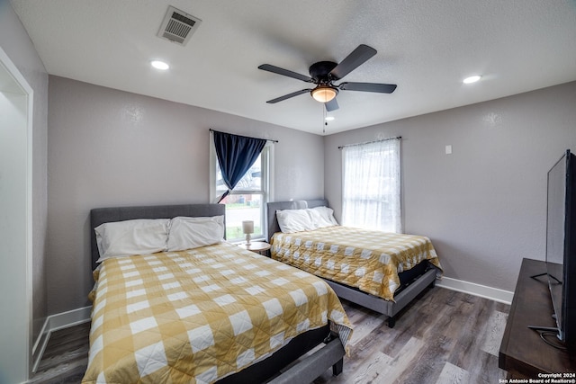 bedroom featuring a textured ceiling, dark hardwood / wood-style flooring, and ceiling fan