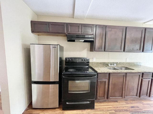 kitchen featuring dark brown cabinetry, sink, black electric range, stainless steel fridge, and light wood-type flooring