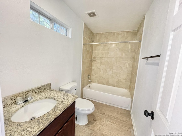 full bathroom featuring toilet, vanity, tiled shower / bath combo, and hardwood / wood-style flooring