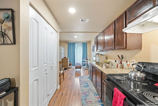 kitchen featuring wood-type flooring, sink, electric range, range hood, and dark brown cabinetry