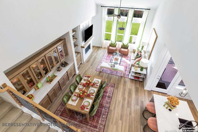 living room featuring hardwood / wood-style floors, ceiling fan, and a high ceiling