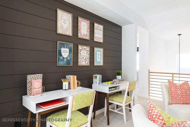 dining area with carpet flooring and wooden walls