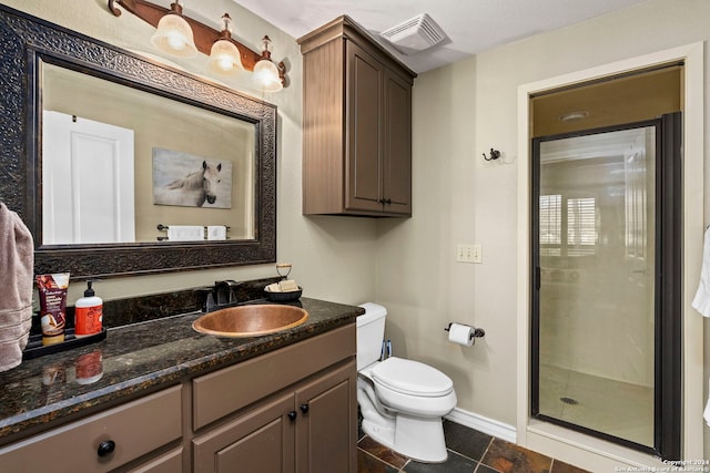 bathroom with vanity, toilet, and a shower with shower door