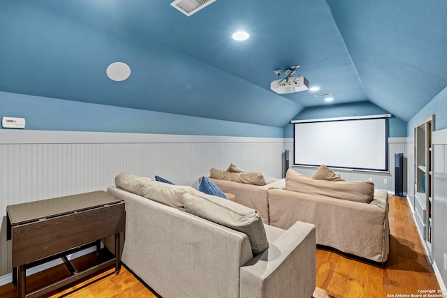 cinema room featuring light hardwood / wood-style floors and lofted ceiling