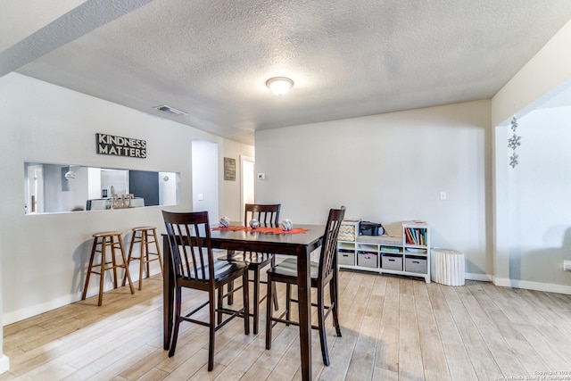 dining area featuring hardwood / wood-style floors and a textured ceiling