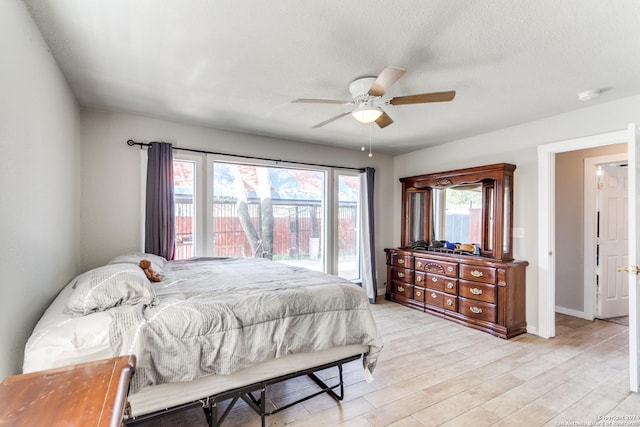 bedroom with ceiling fan, a textured ceiling, and light hardwood / wood-style flooring