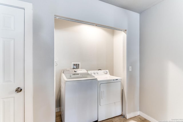 washroom featuring a textured ceiling and washer and clothes dryer