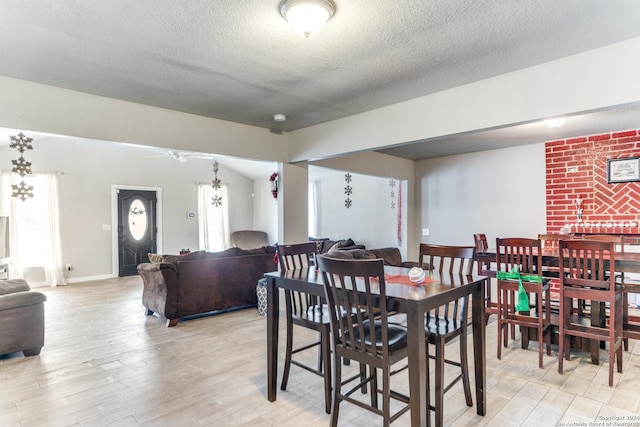 dining room featuring ceiling fan, light hardwood / wood-style flooring, and a textured ceiling