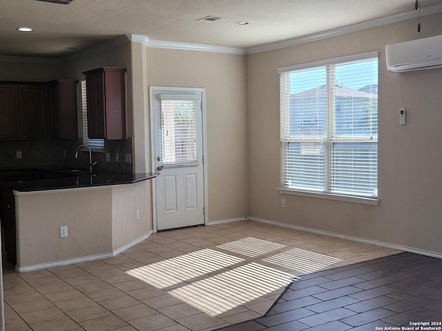 kitchen featuring sink, a wall mounted AC, crown molding, decorative backsplash, and dark brown cabinets