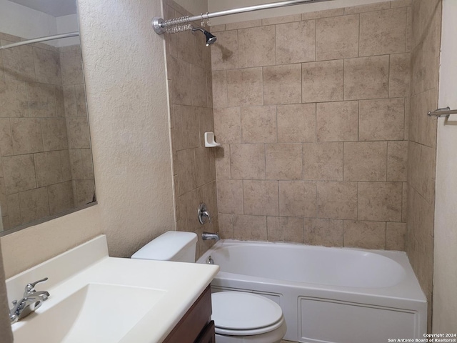 full bathroom featuring vanity, tiled shower / bath, and toilet