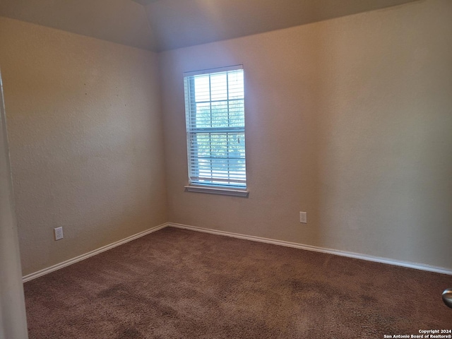 unfurnished room with carpet and vaulted ceiling