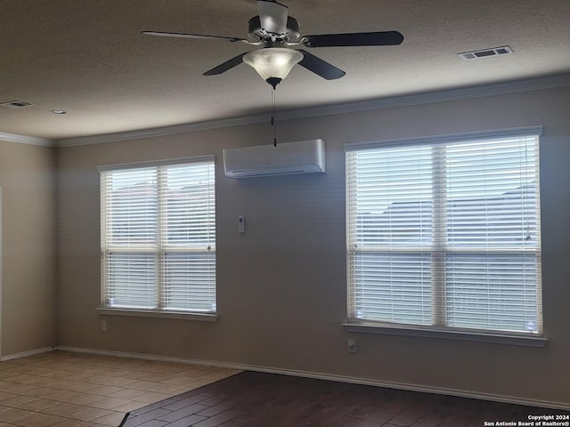 empty room featuring a wall unit AC, ceiling fan, a healthy amount of sunlight, and crown molding