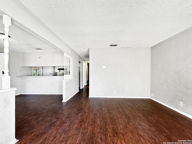 unfurnished room featuring a textured ceiling and dark wood-type flooring