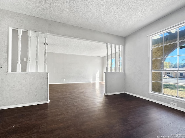 unfurnished room featuring a textured ceiling and dark hardwood / wood-style floors