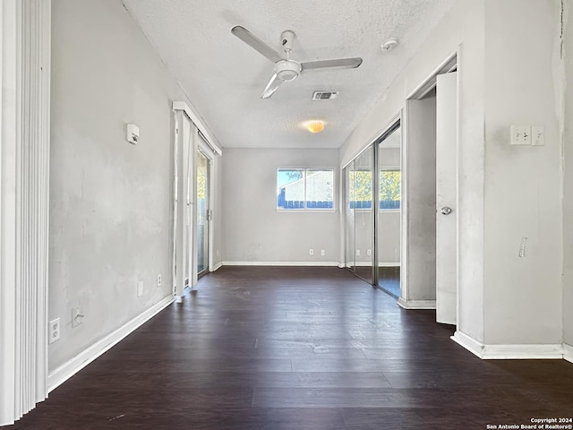 unfurnished room with a textured ceiling, dark hardwood / wood-style floors, and ceiling fan