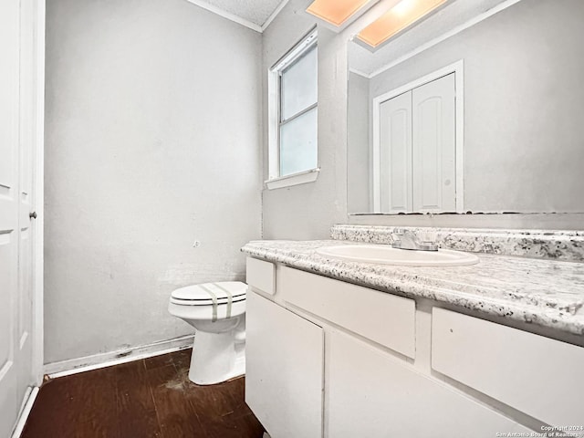 bathroom featuring hardwood / wood-style floors, vanity, toilet, and crown molding