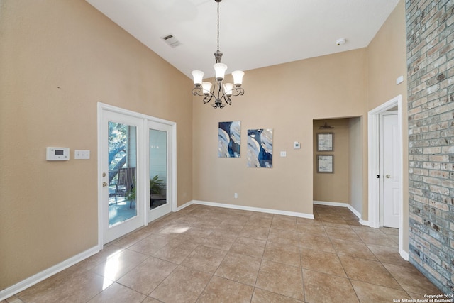 spare room with light tile patterned flooring and an inviting chandelier