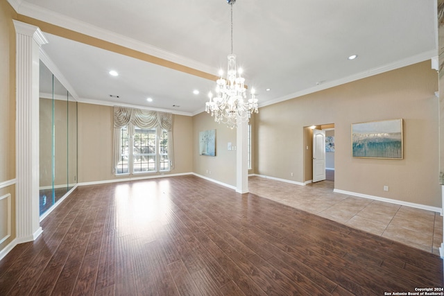 unfurnished living room featuring hardwood / wood-style floors, ornamental molding, and an inviting chandelier