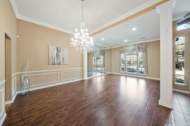 interior space featuring dark hardwood / wood-style floors, ornate columns, ornamental molding, and a chandelier