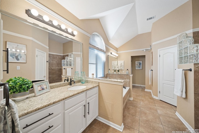 bathroom with tile patterned floors, vanity, lofted ceiling, and a tub to relax in