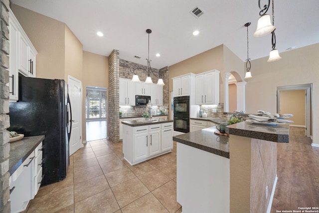 kitchen with white cabinets, black appliances, and decorative light fixtures