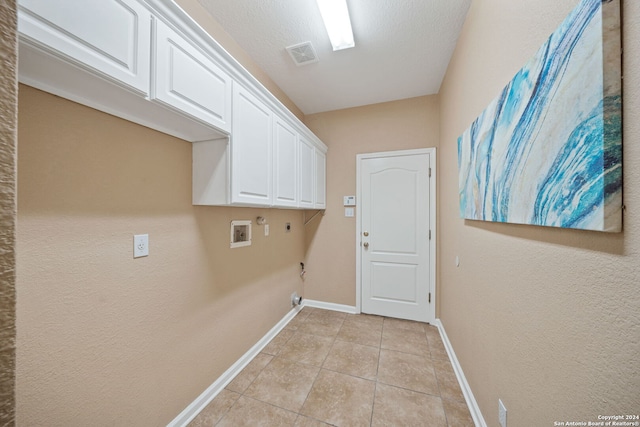 washroom featuring cabinets, washer hookup, hookup for an electric dryer, gas dryer hookup, and light tile patterned floors