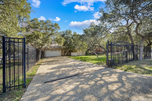 view of gate with a yard and a garage