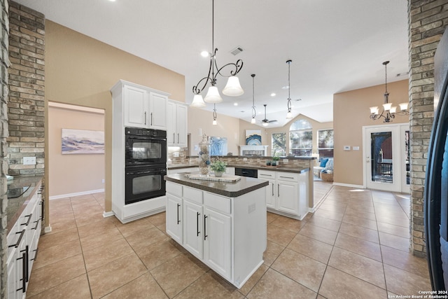 kitchen with white cabinets, ceiling fan with notable chandelier, a kitchen island, and decorative light fixtures