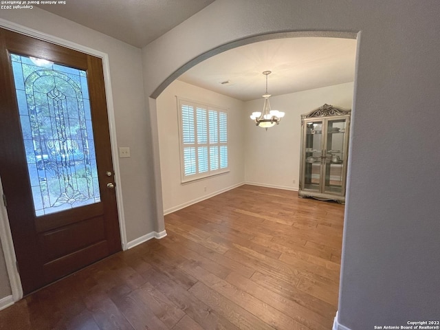 foyer entrance featuring hardwood / wood-style flooring and an inviting chandelier