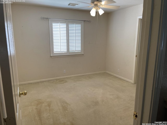 carpeted empty room featuring ceiling fan