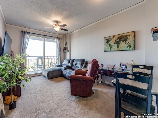 living room with carpet flooring, ceiling fan, a textured ceiling, and ornamental molding