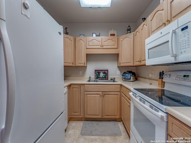 kitchen with light brown cabinets, white appliances, and sink