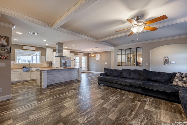 living room featuring dark hardwood / wood-style flooring, a wealth of natural light, crown molding, and ceiling fan