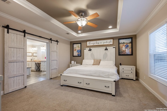 carpeted bedroom with a raised ceiling, a barn door, ceiling fan, and ornamental molding