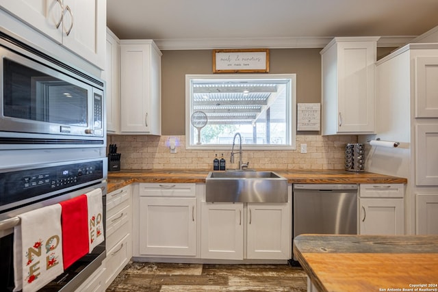 kitchen with white cabinetry, sink, stainless steel appliances, and wooden counters