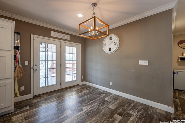 entryway with crown molding, dark wood-type flooring, and a notable chandelier