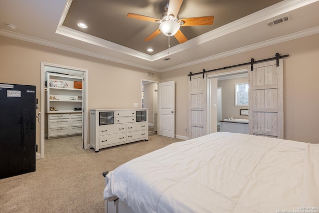 carpeted bedroom featuring a barn door, a raised ceiling, ceiling fan, and ornamental molding