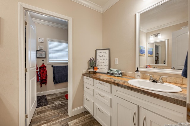 bathroom with wood-type flooring, vanity, and ornamental molding