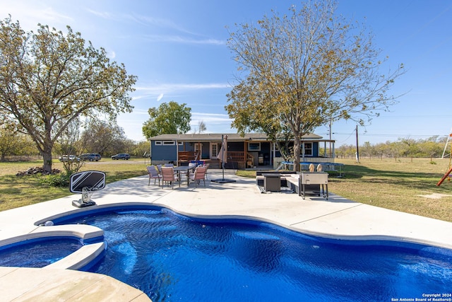 view of pool featuring an in ground hot tub, a yard, and a patio