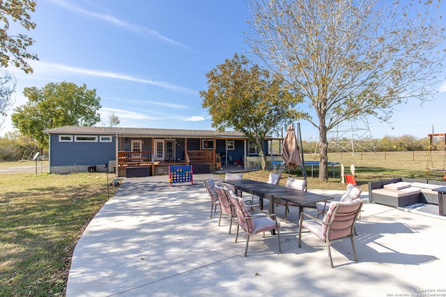 view of patio with a trampoline, a deck, and an outdoor fire pit