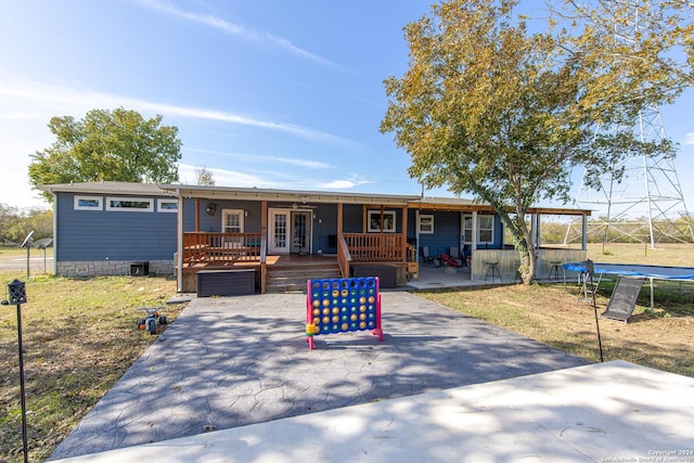 view of front of property with a front yard, a patio, a trampoline, and a deck