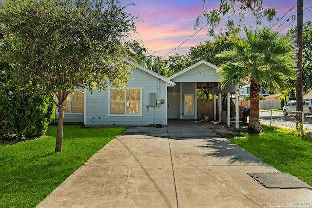 view of front of property featuring a carport and a yard