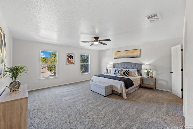 carpeted bedroom with ceiling fan and a textured ceiling