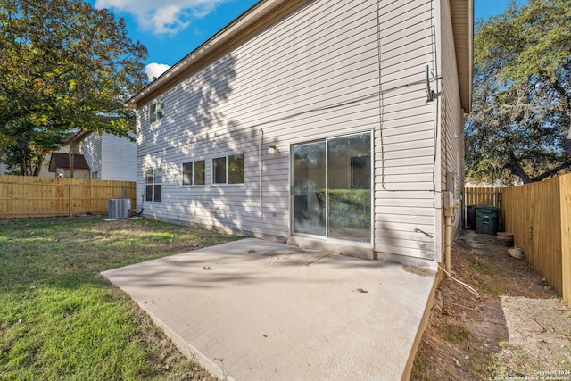 rear view of property featuring a lawn, a patio area, and central AC unit