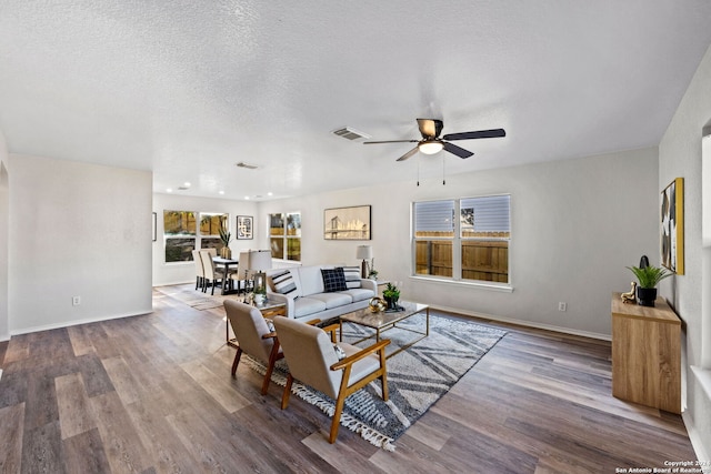 living room with wood-type flooring, a textured ceiling, and ceiling fan