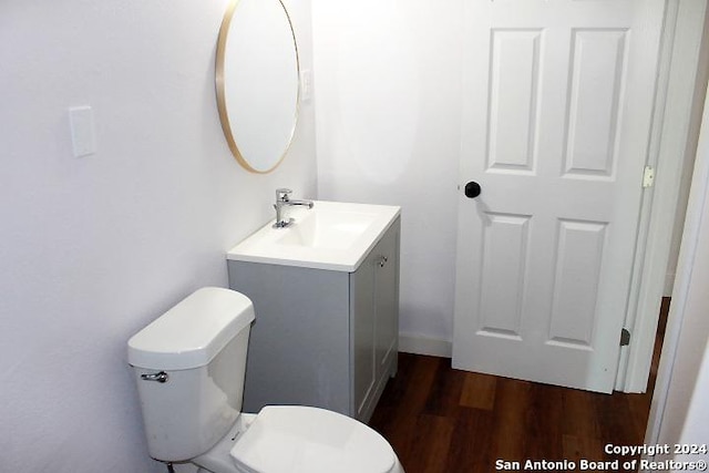 bathroom with hardwood / wood-style floors, vanity, and toilet