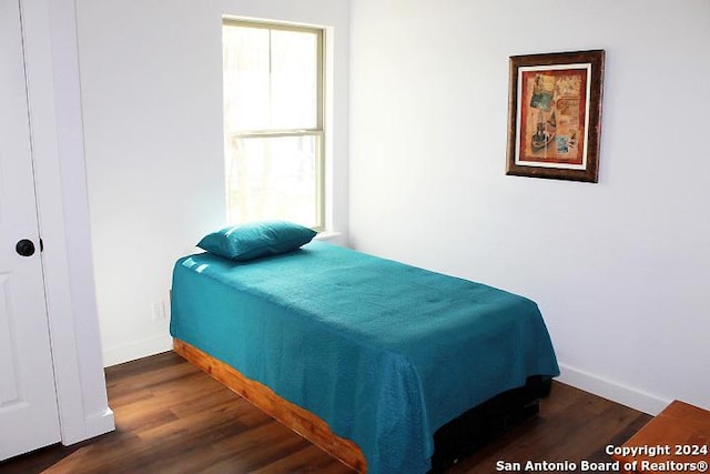 bedroom with dark wood-type flooring