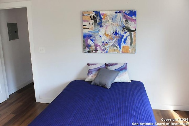 bedroom with dark hardwood / wood-style flooring and electric panel