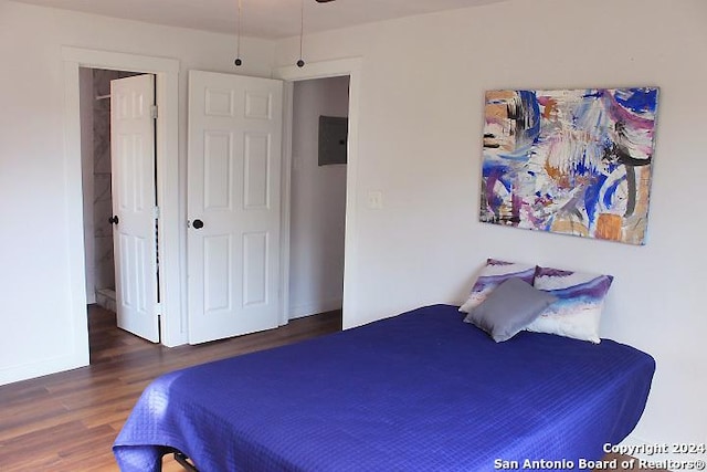 bedroom with dark wood-type flooring and electric panel