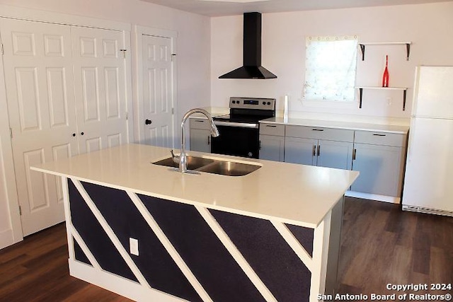 kitchen with dark wood-type flooring, exhaust hood, white refrigerator, stainless steel electric range oven, and an island with sink